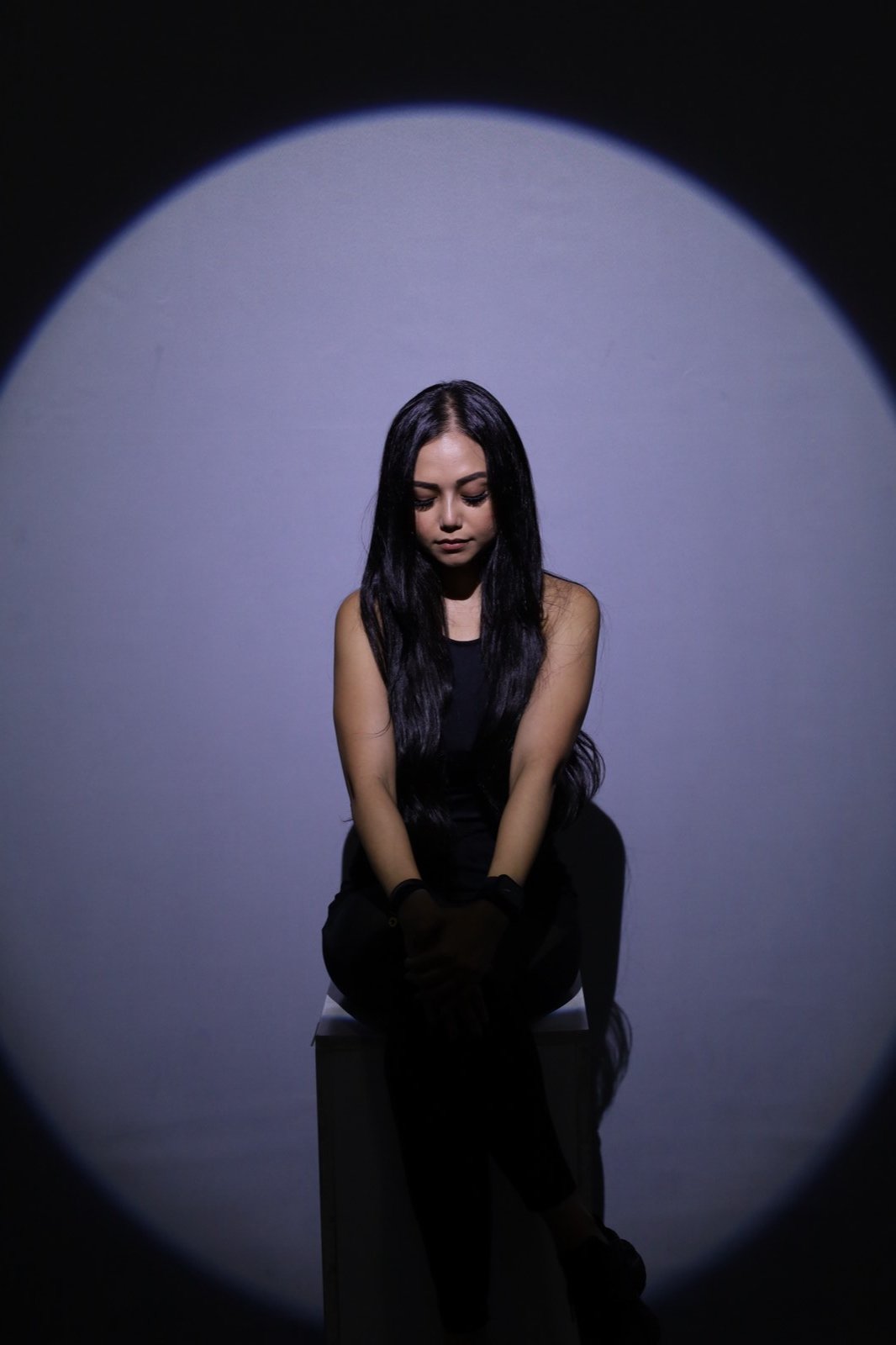 Taz Angullia lit by a single spotlight